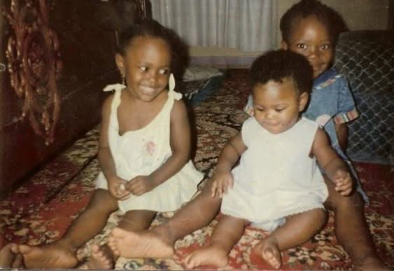 Amal sitting with family members in a childhood photograph