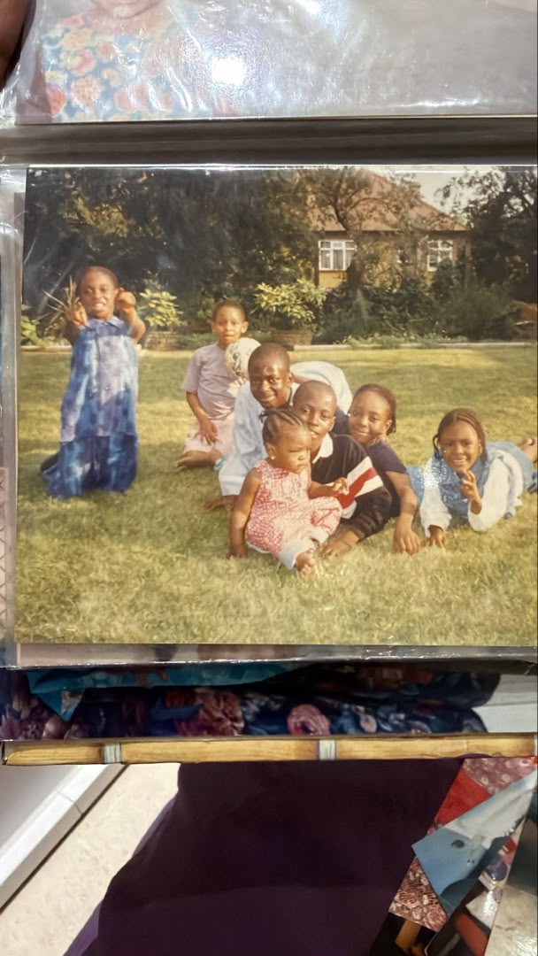 Amal with family members on a lawn in a childhood photograph