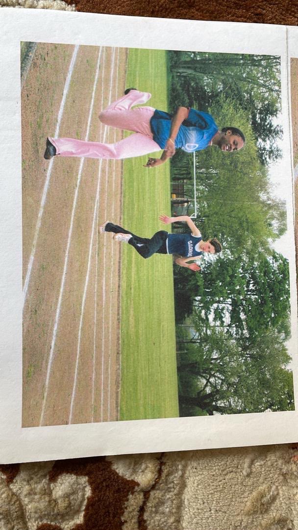 Amal, the Black runner in blue and pink, racing on a school track