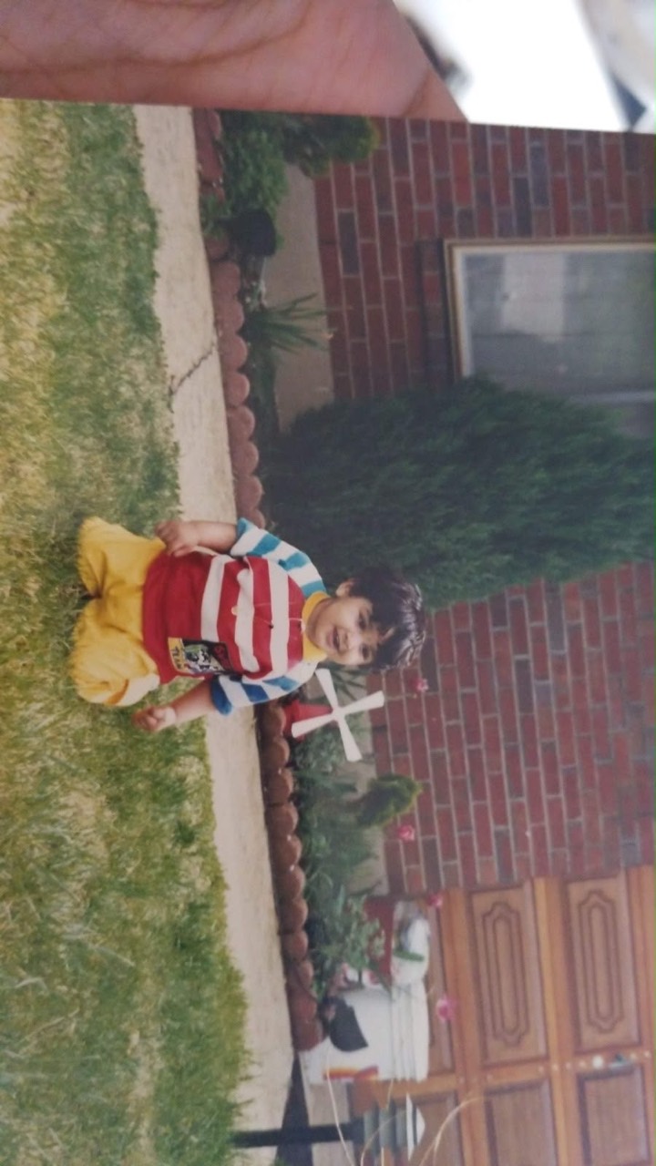 Usman as a young child sitting upright on the lawn