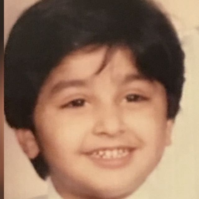 A childhood portrait of Usman smiling